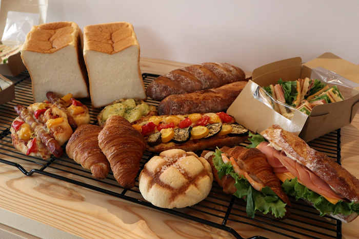 岩本こむぎ店　大人気のモチモチ食パンに、店主が作る気まぐれサンドなど、店内は 30種類ほどのパンが種類豊富に並んでいます。